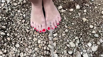 college woman peeing on sand at beach while standing up